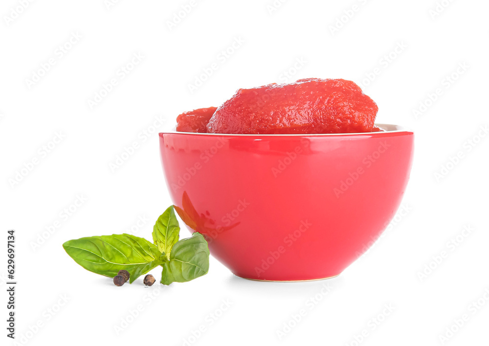 Bowl of canned tomatoes and basil on white background