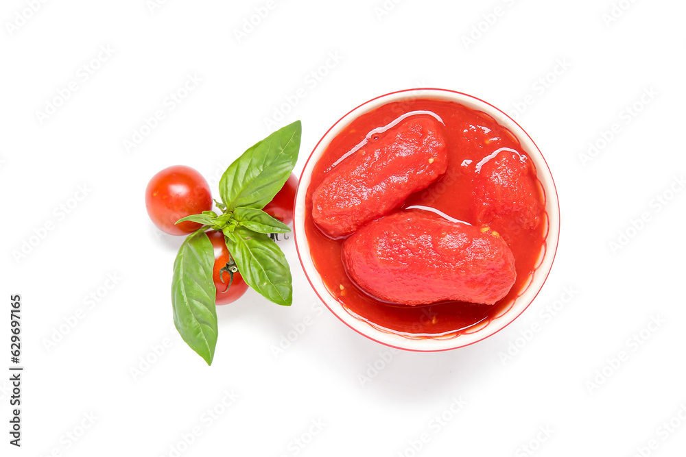 Bowl of canned tomatoes and basil on white background