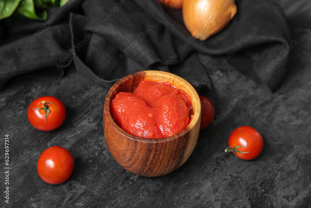 Bowl of canned tomatoes on dark background