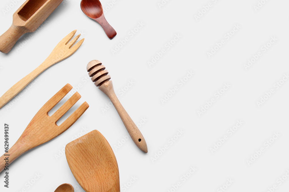 Set of different wooden kitchen utensils on white background