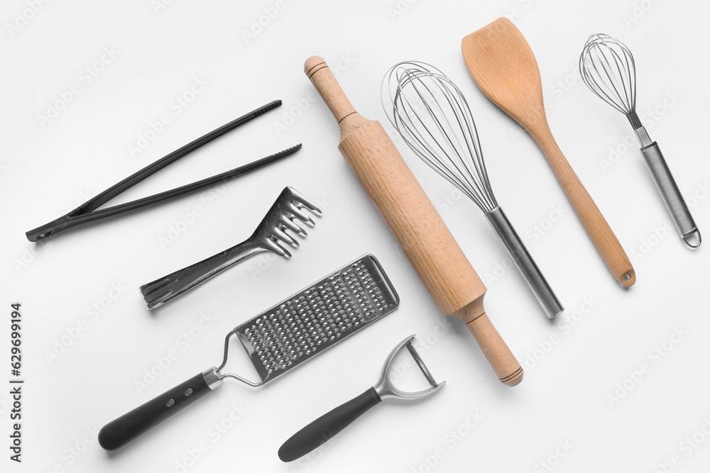 Composition with different kitchen utensils on light background