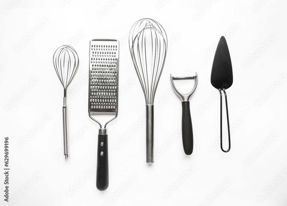 Set of stainless steel kitchen utensils on light background