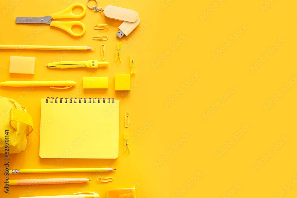 Different school stationery and notebook on orange background