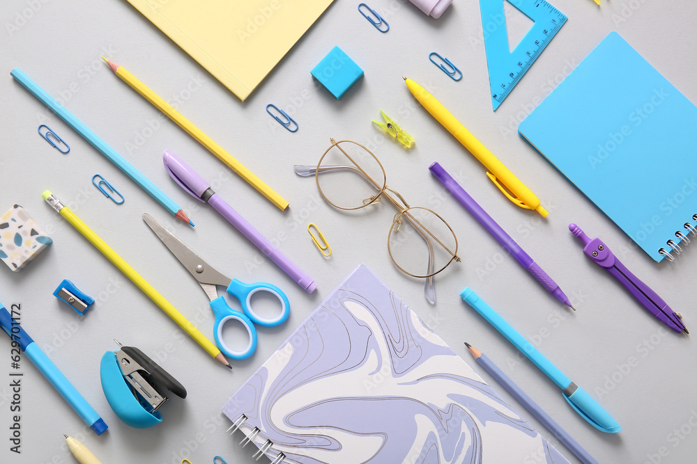 Different school stationery and notebooks on grey background