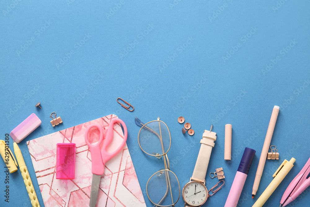 Different school stationery, notebook and  glasses on blue background