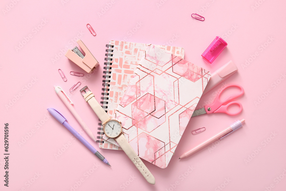 Different school stationery, notebooks and wristwatch on pink background