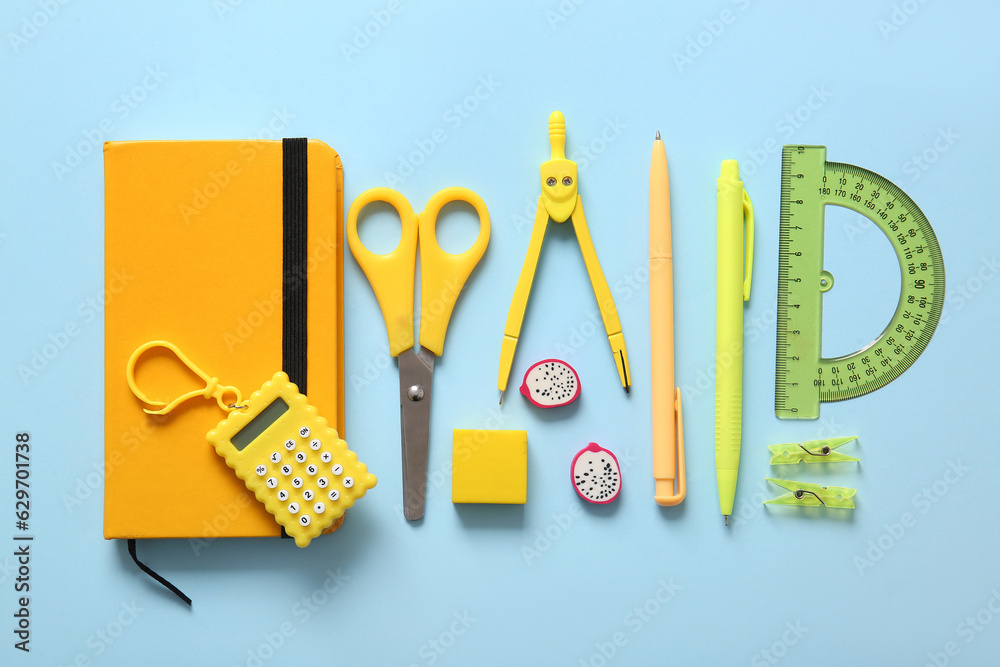 Different school stationery and notebook on blue background