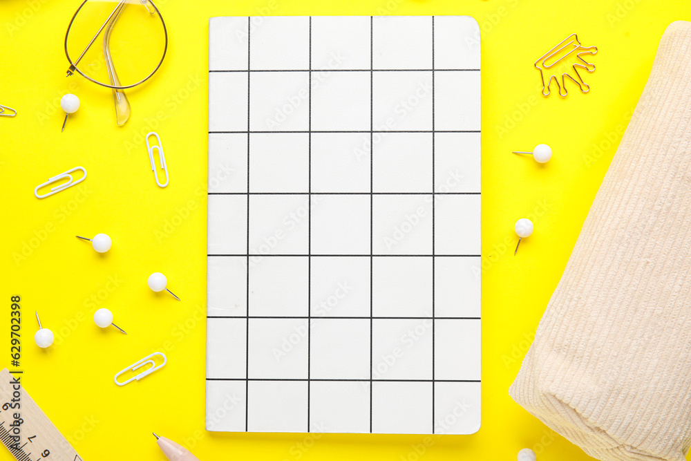 Set of stationery with notebook on yellow background