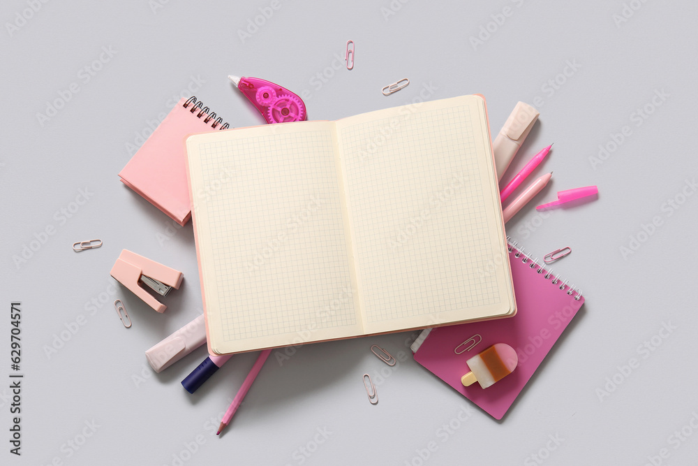 Composition with blank notebook and different school stationery on light background