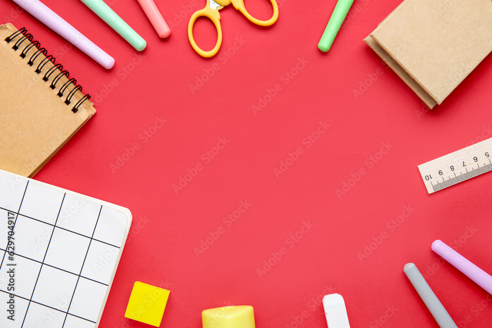 Frame made of different stationery on red background