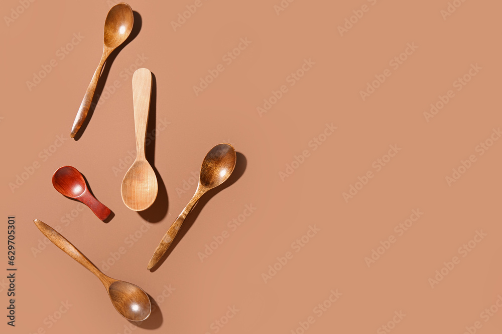 Set of wooden spoons on color background