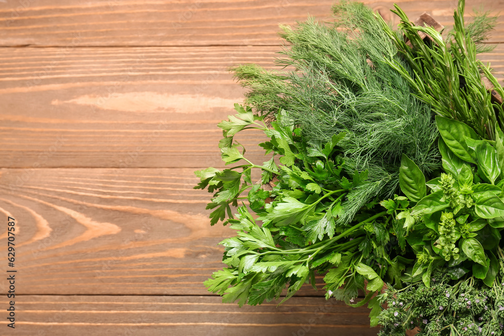 Assortment of fresh herbs on wooden background