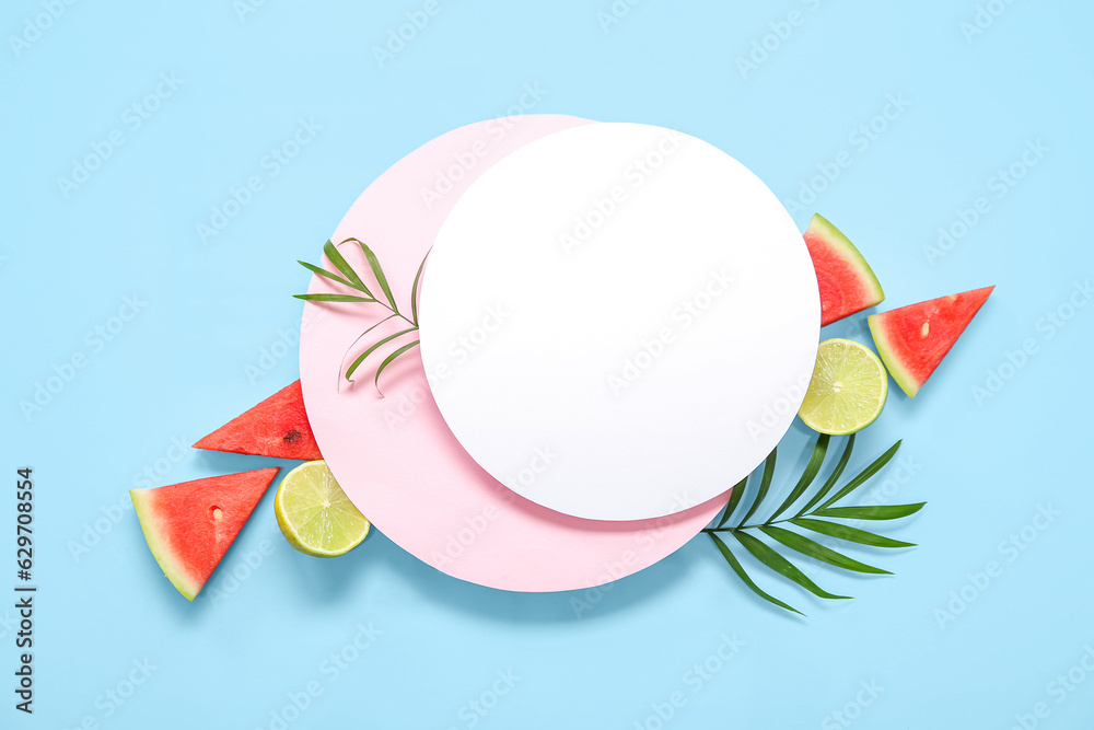 Blank card with pieces of fresh watermelon and lime on blue background