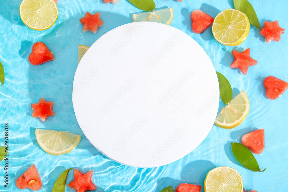 Blank card and pieces of fresh watermelon with lemon in water on blue background