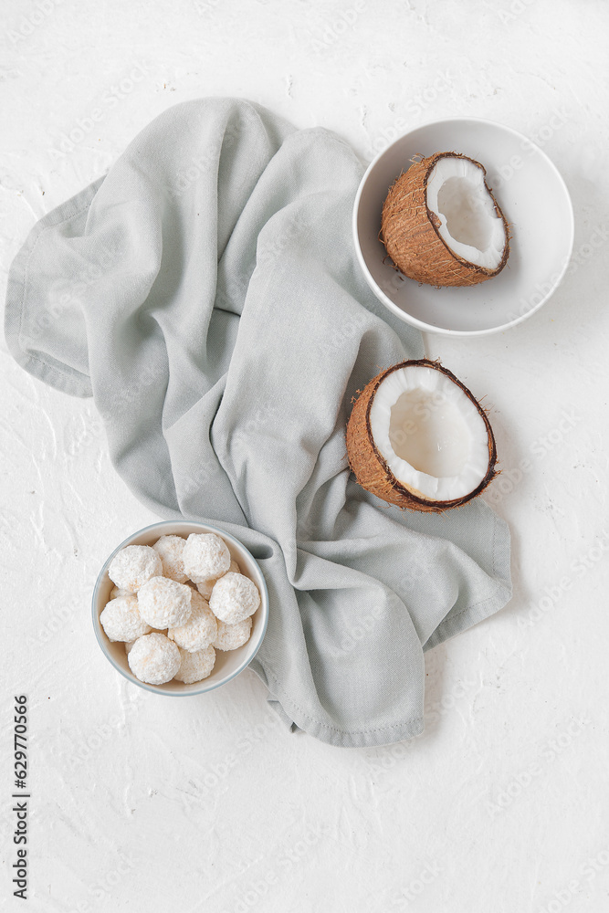 Bowl with white chocolate candies and coconuts on light table