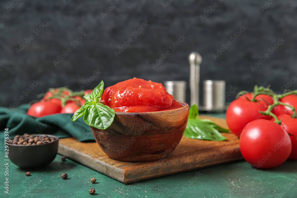 Bowl of canned tomatoes and peppercorns on color table