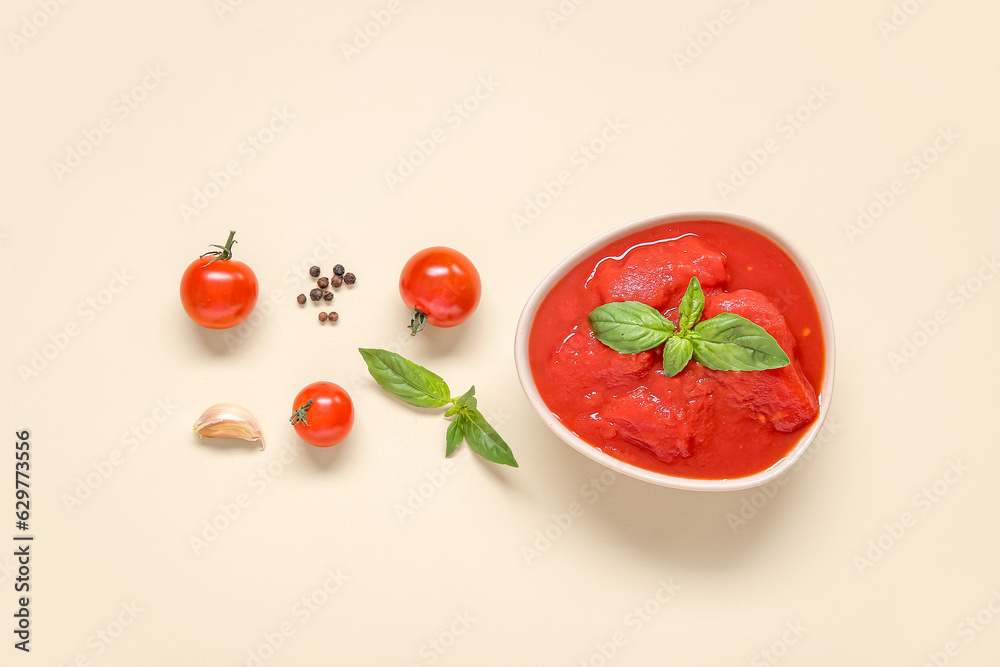 Composition with bowl of tasty canned tomatoes and spices on color background