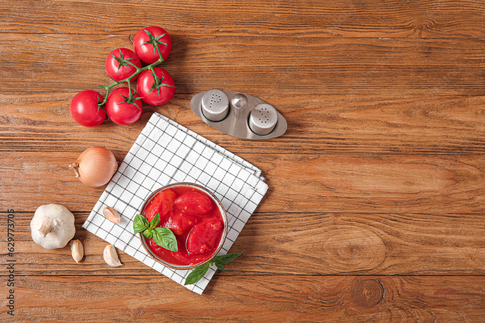 Composition with spices, canned and fresh tomatoes on wooden background