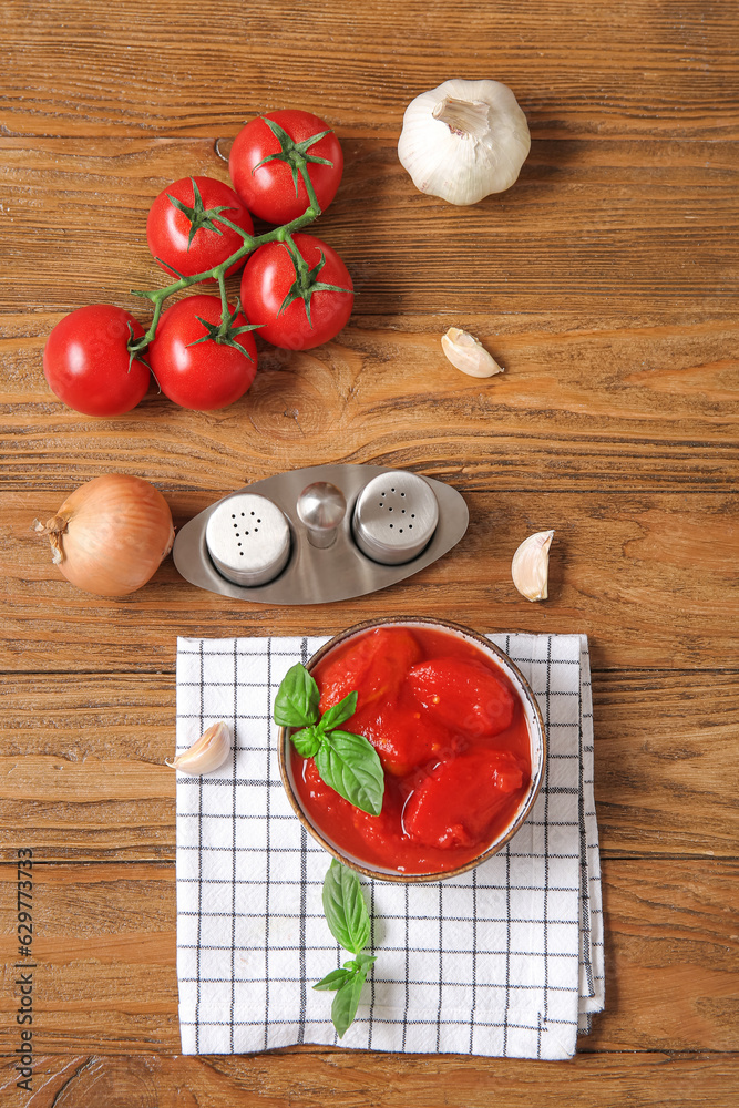 Composition with spices, canned and fresh tomatoes on wooden background