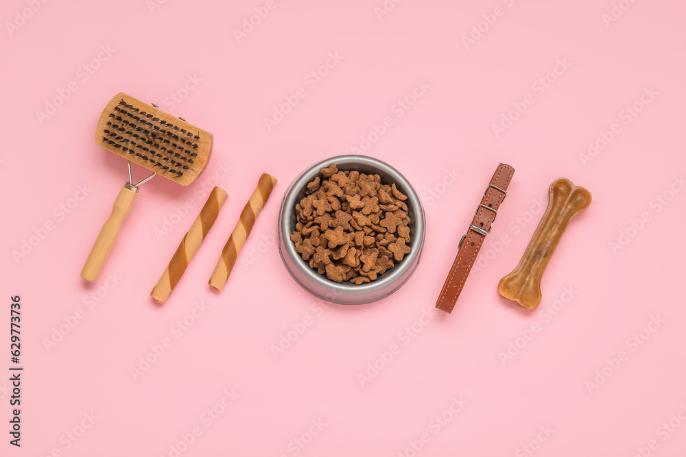 Composition with pet collar, grooming brush and food on pink background