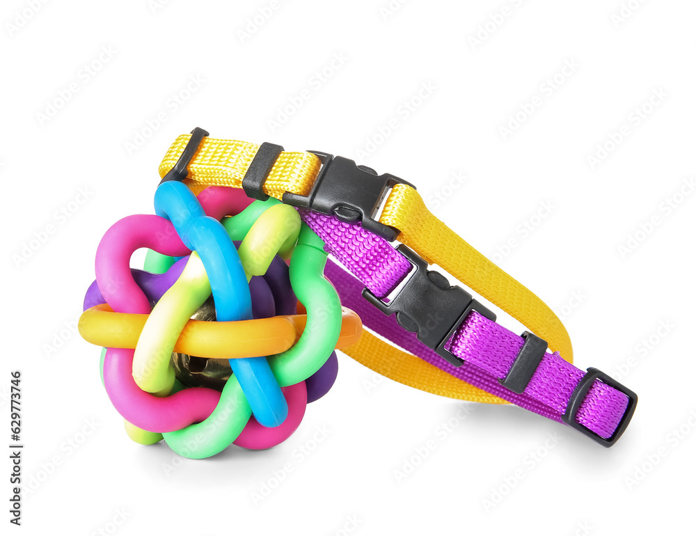 Colorful pet collars and toy ball on white background