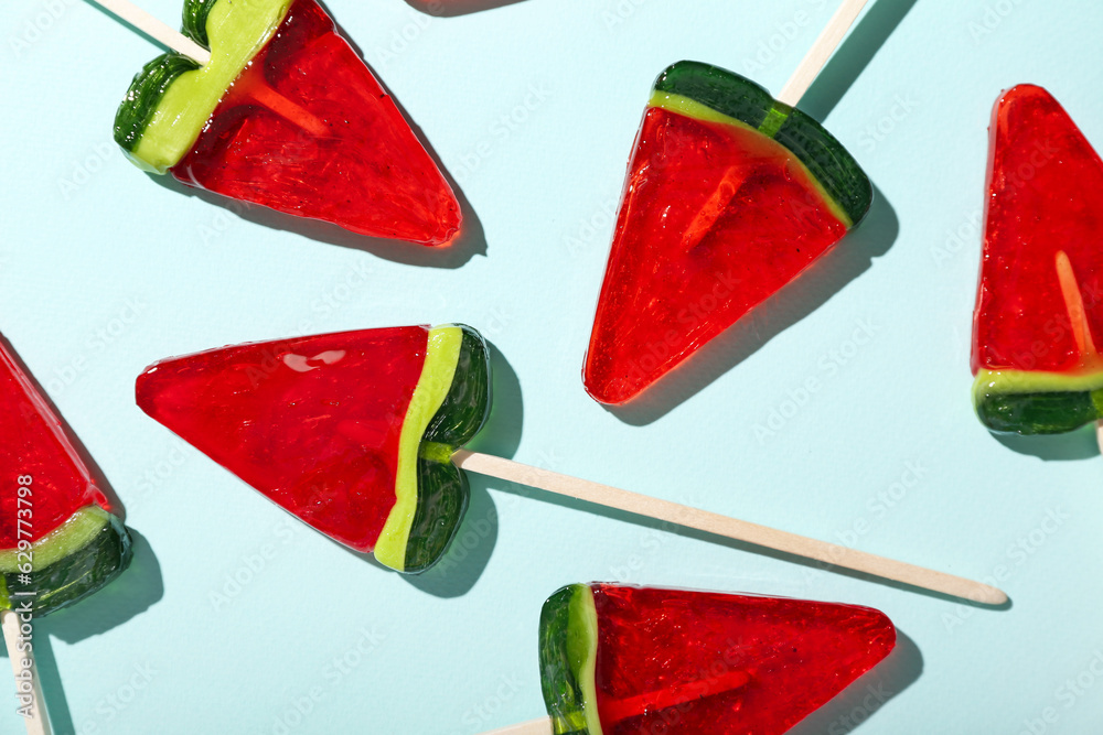 Lollipops in shape of watermelon slice on blue background