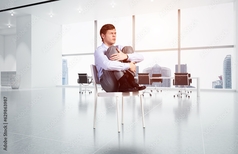 scared businessman on a chair in office