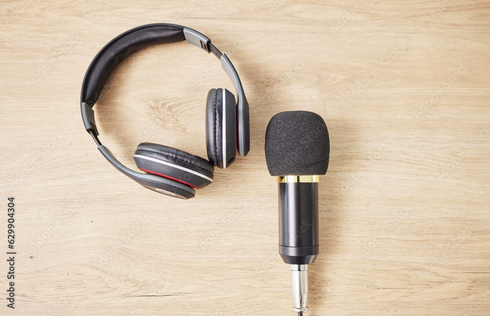 Above, microphone and headphones on a table for a podcast, radio or broadcast. Music, desk or musica