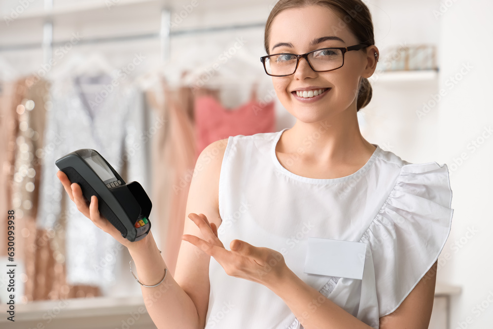 Female seller with payment terminal in boutique