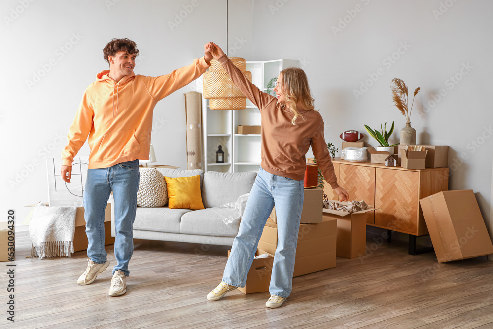 Young couple dancing in room on moving day