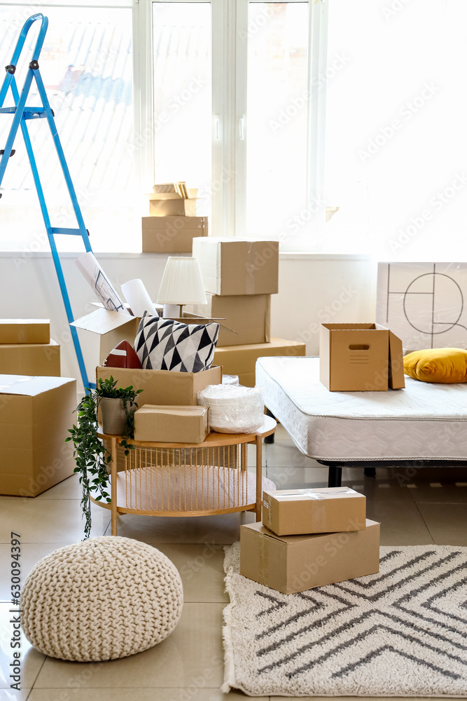 Table with cardboard boxes in bedroom on moving day