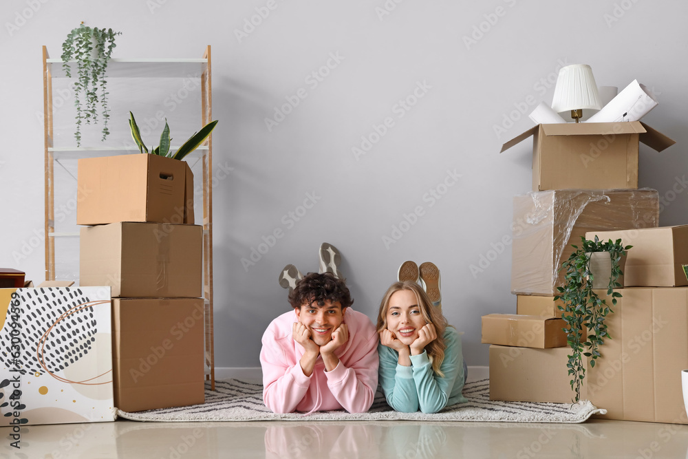 Happy young couple lying in room on moving day