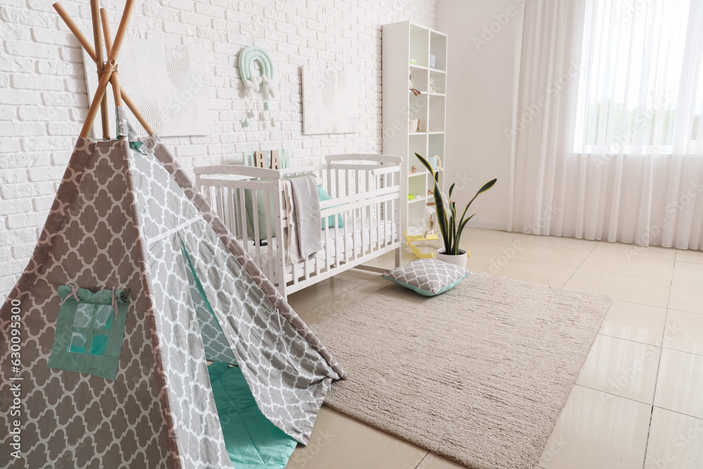 Stylish modern interior of childrens room with baby bed and play tent