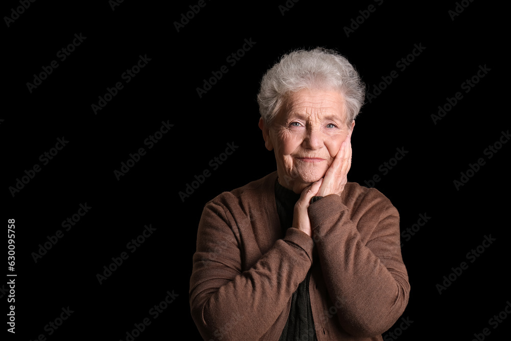 Senior woman on black background