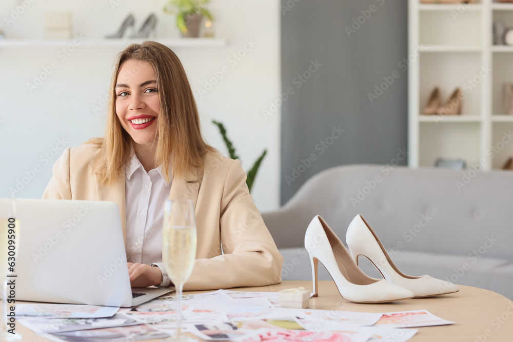 Female wedding planner working with laptop at table in office