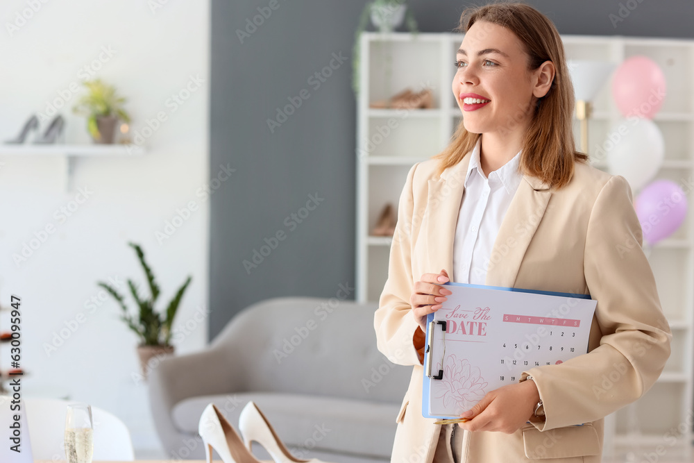 Female wedding planner with Save the Date Announcement in office