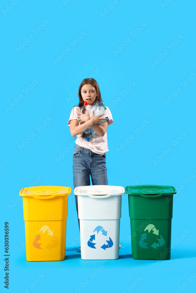 Little girl with plastic bottles and recycle bins on blue background