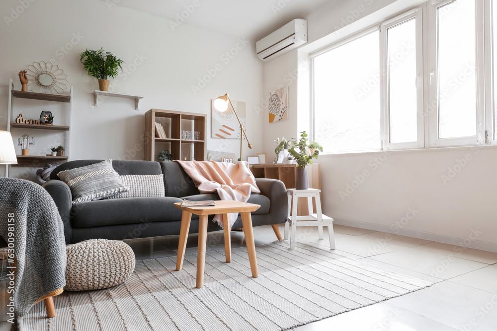 Interior of light living room with glowing lamps and sofa