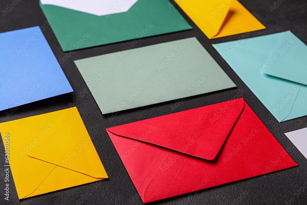 Composition with colorful envelopes on dark background, closeup