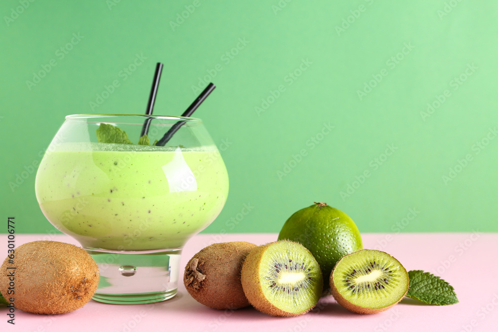 Glass of fresh kiwi smoothie with mint and lime on colorful background