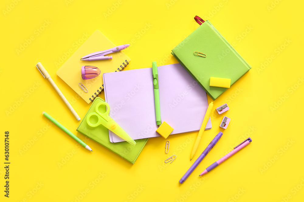 Different school stationery and notebooks on yellow background