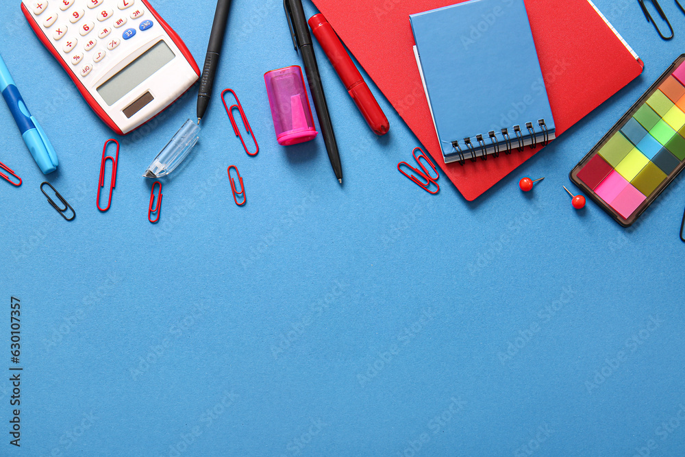 Different school stationery and notebooks on blue background