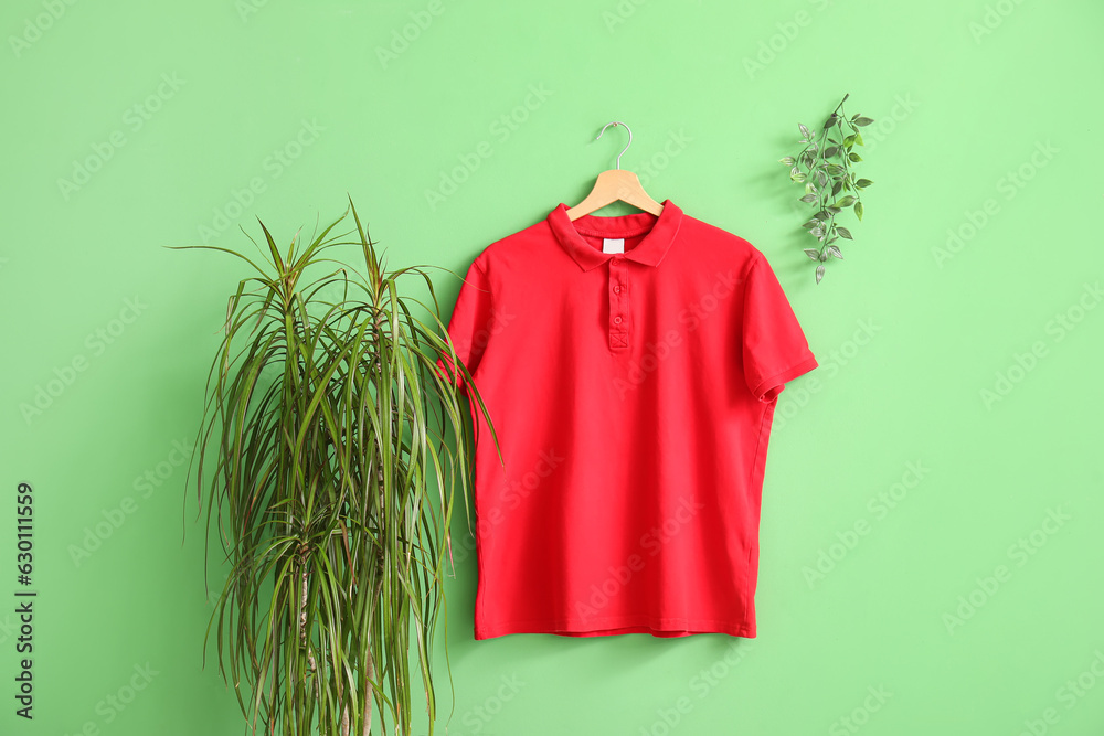 Stylish red t-shirt hanging on green background