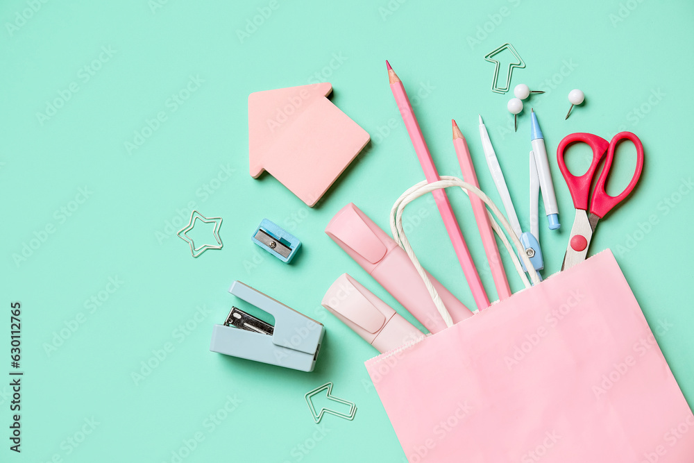 Composition with paper bag and stationery on color background