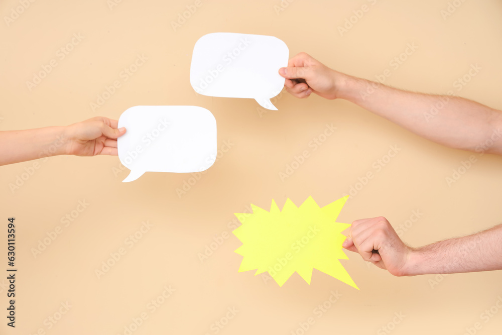 Different hands with speech bubbles on beige background