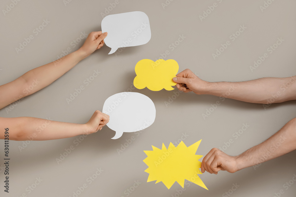 Different hands with speech bubbles on grey background