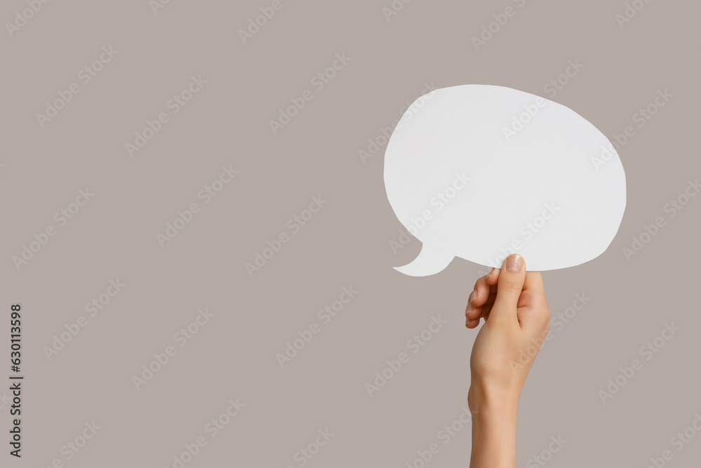 Female hand with speech bubble on grey background