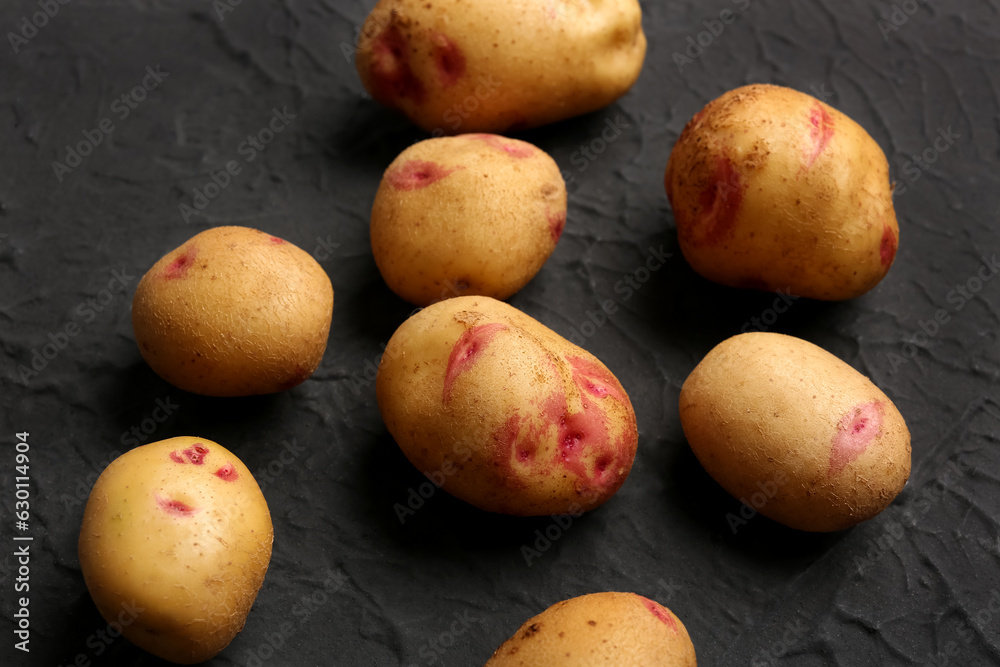 Fresh raw potatoes on black background