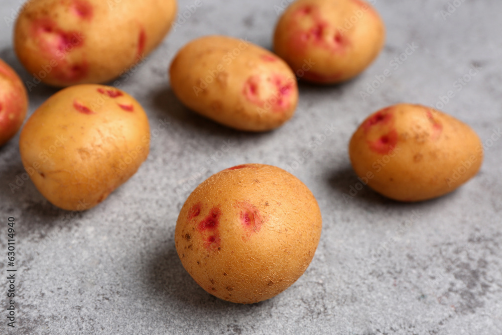 Fresh raw potatoes on blue background