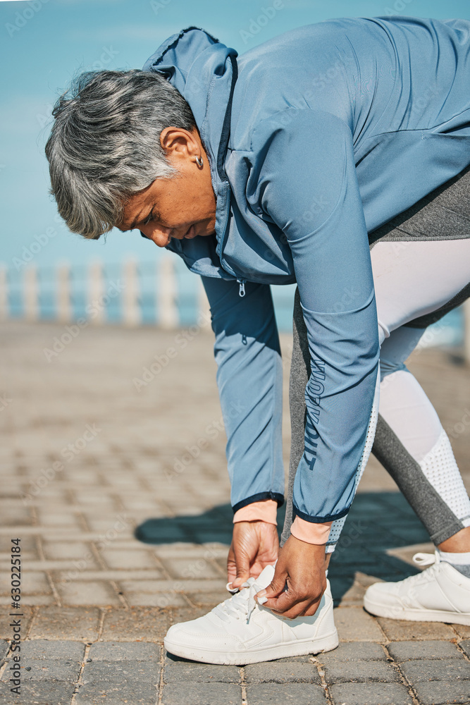 Fitness, beach and senior woman tie shoes ready for wellness, workout or training in the morning for